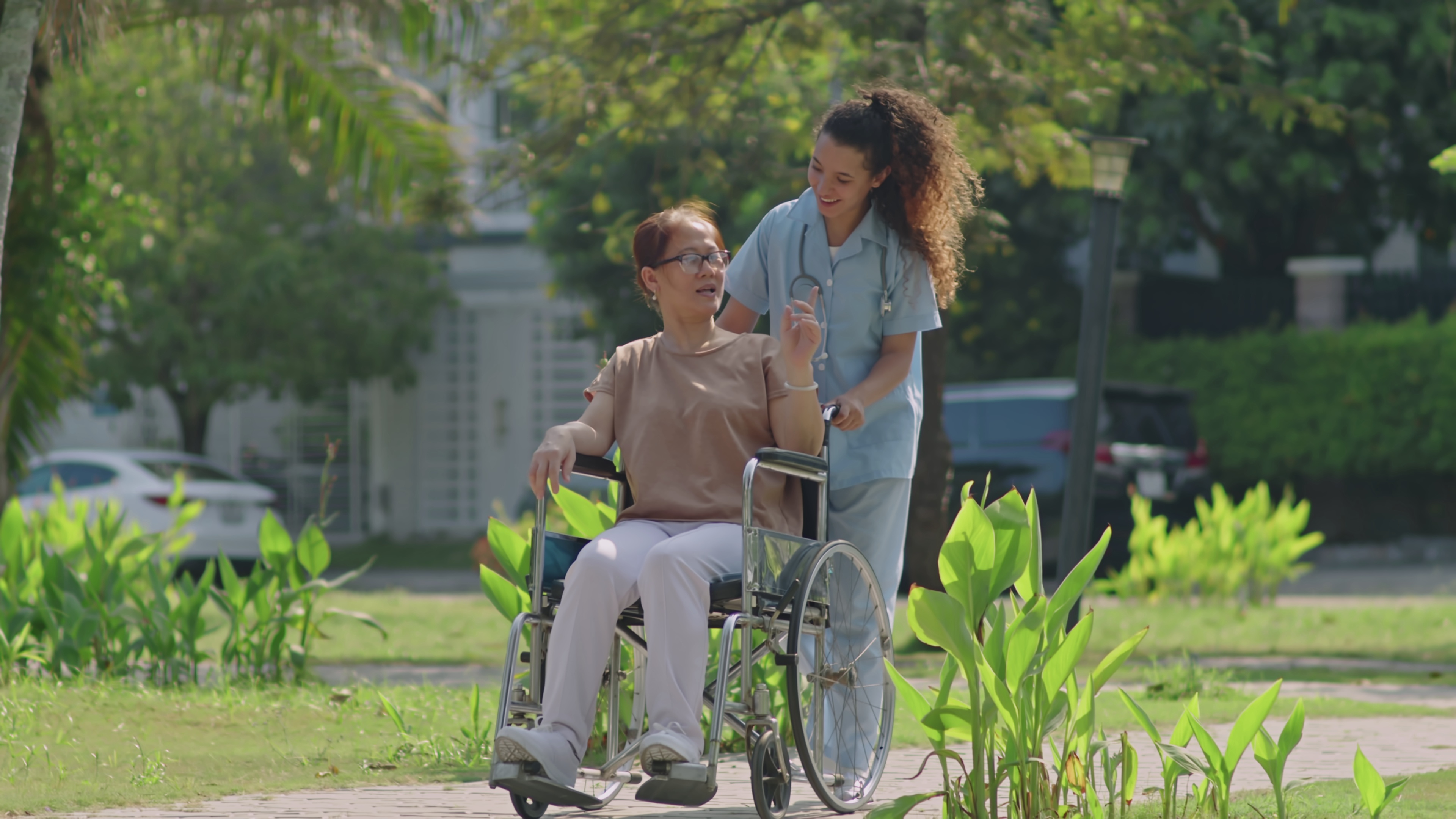 Nurse pushing a patient outside in a wheelchair
