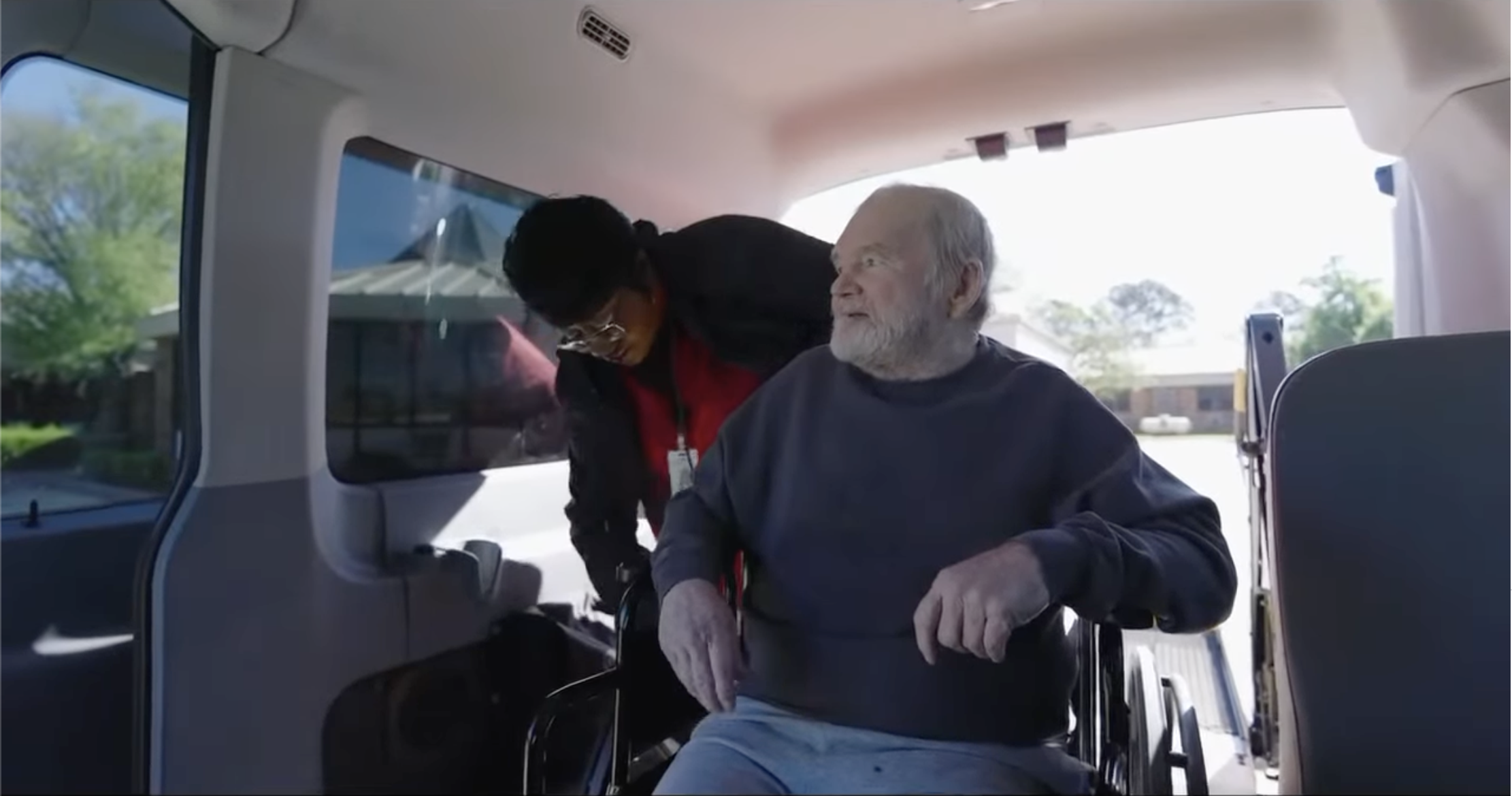 Staff helping a resident into a van
