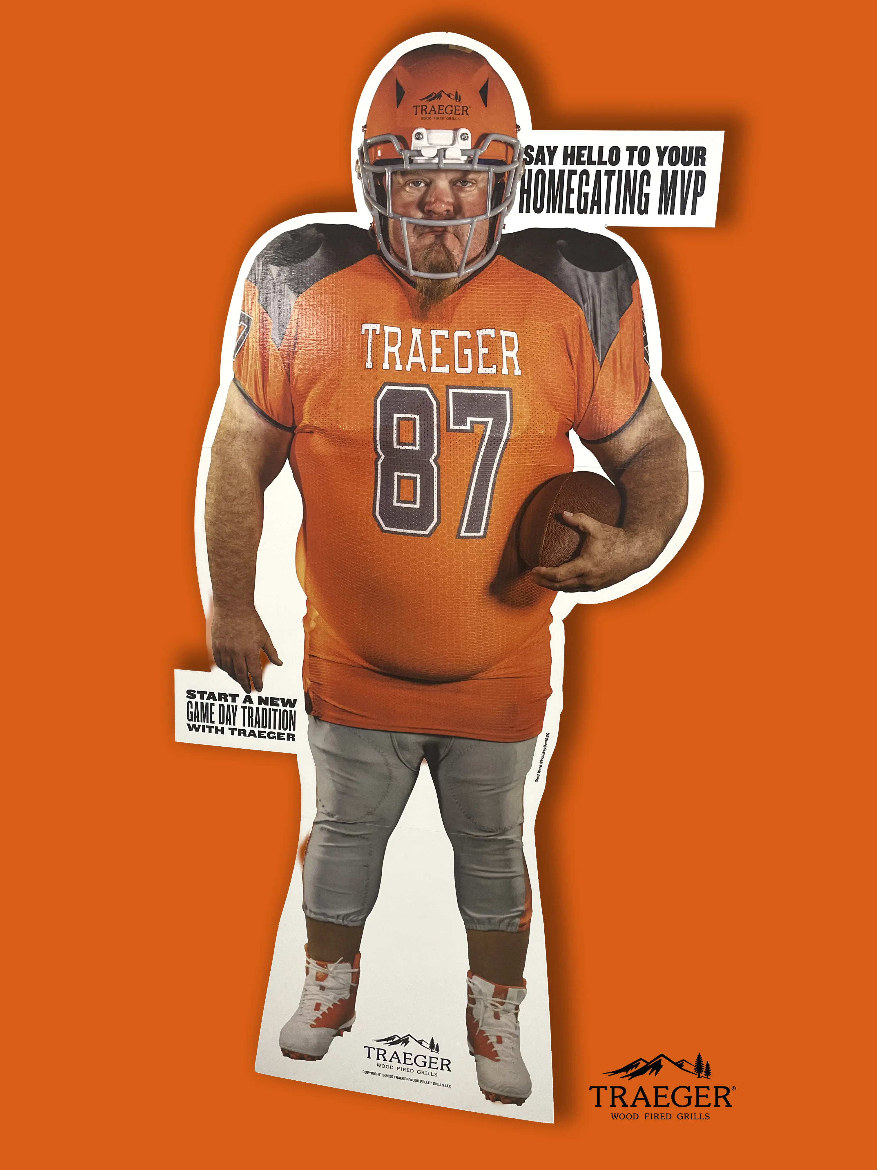 A life-size football cutout in the Traeger orange and black colors.