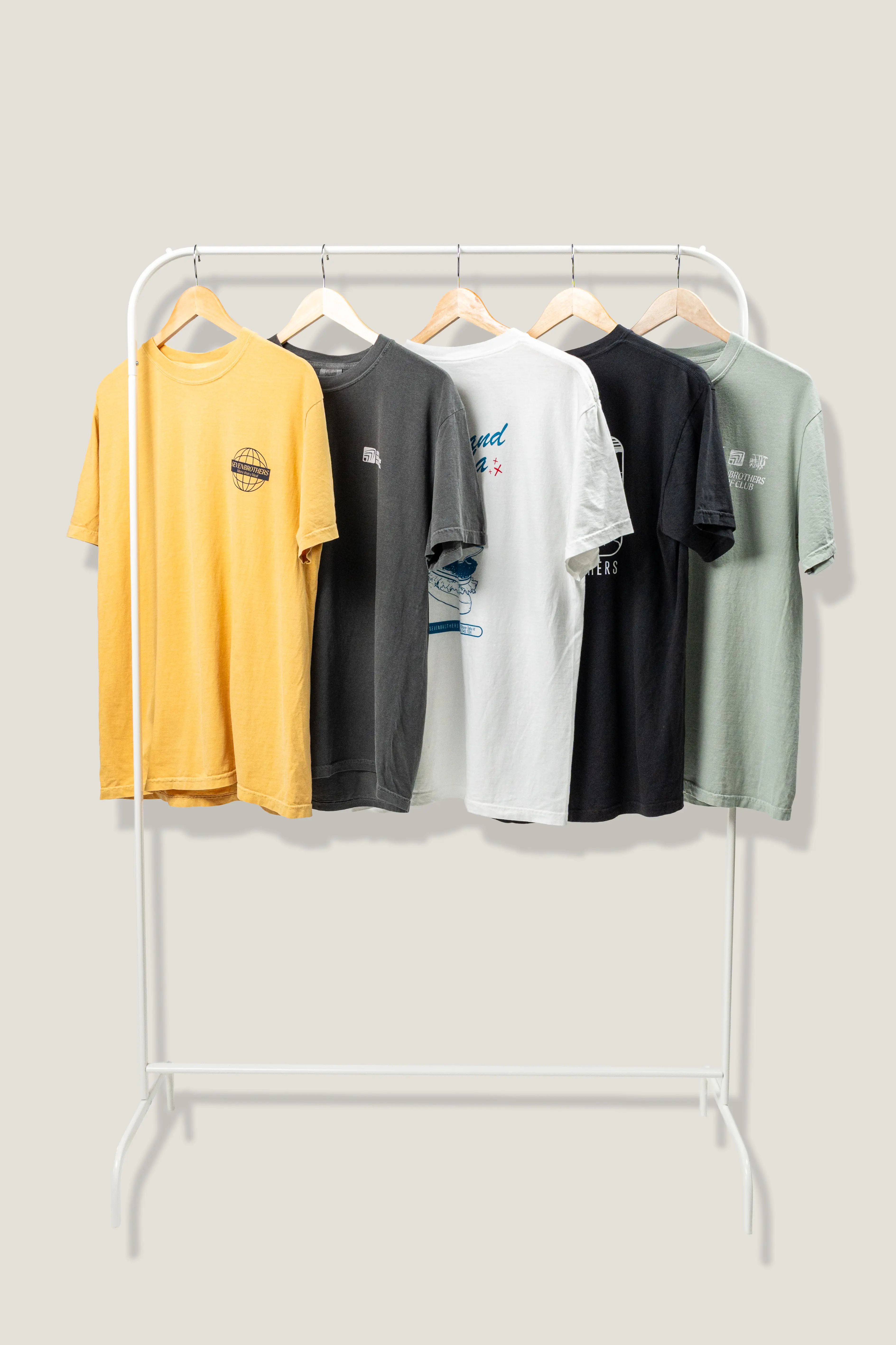 A clothing rail with five different colors of Seven Brothers tshirts