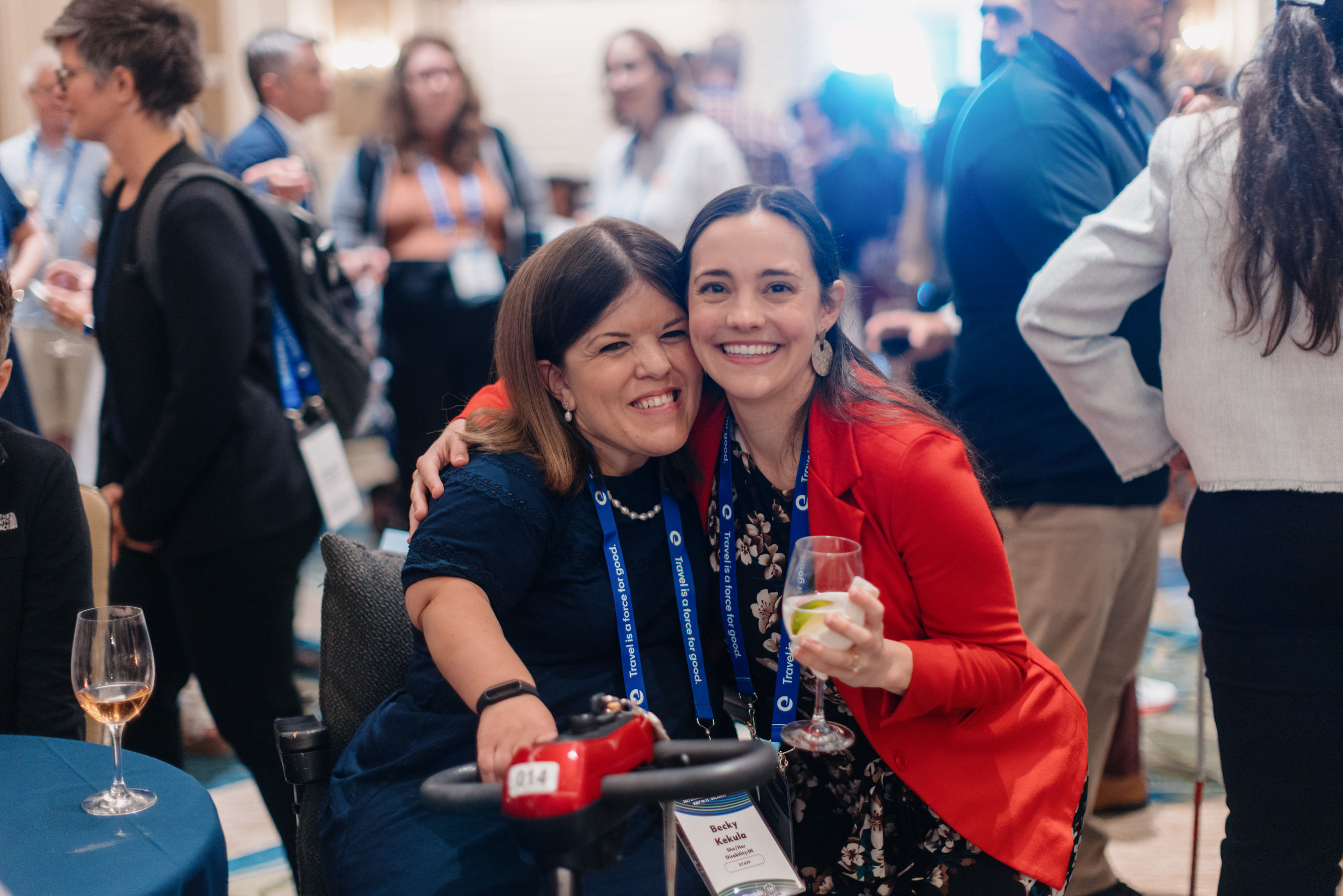 Two conference attendees smile for a photo while networking at a Disability:IN conference reception surrounded by fellow participants.
