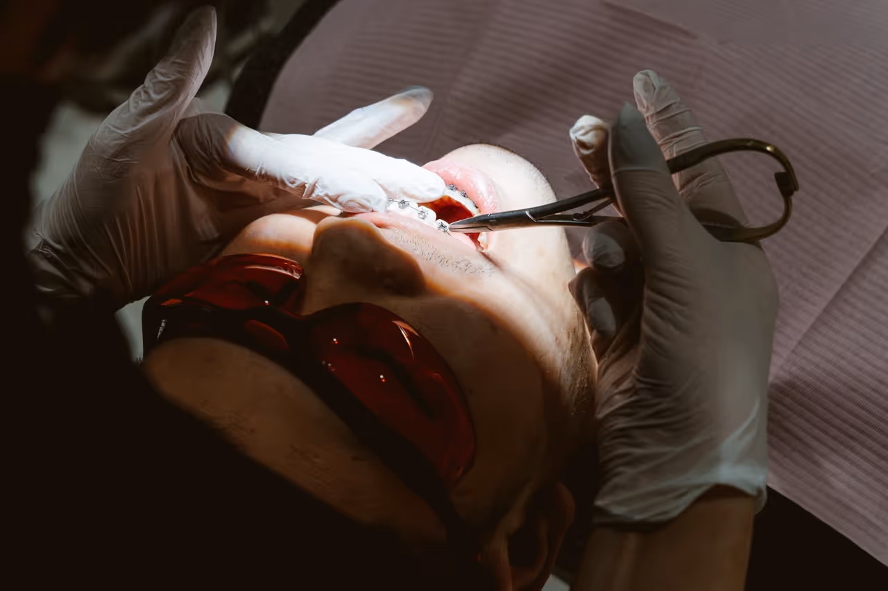 Close-up of an orthodontist adjusting a patient's fixed braces