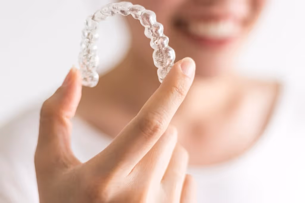 woman holding Invsialign in her hand