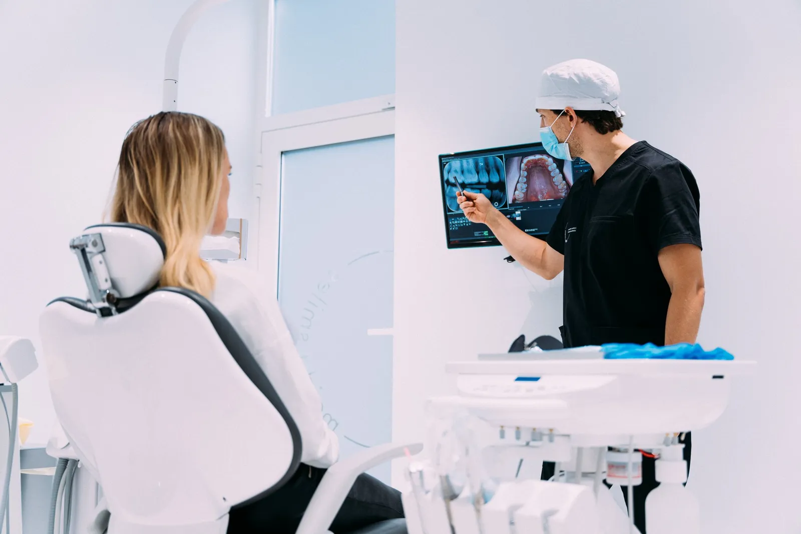 Dentist explaining diagnostic images to a patient in the treatment chair