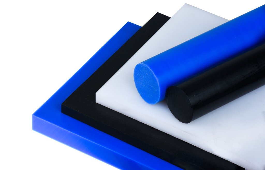 Stack of rectangular plastic sheets in blue, black, and white with cylindrical rods in blue and black on top.