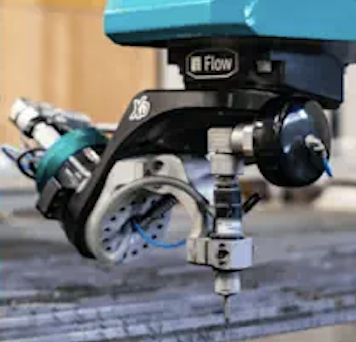 Close-up of a precision CNC milling machine spindle with a cutting tool and flow sensor attached.