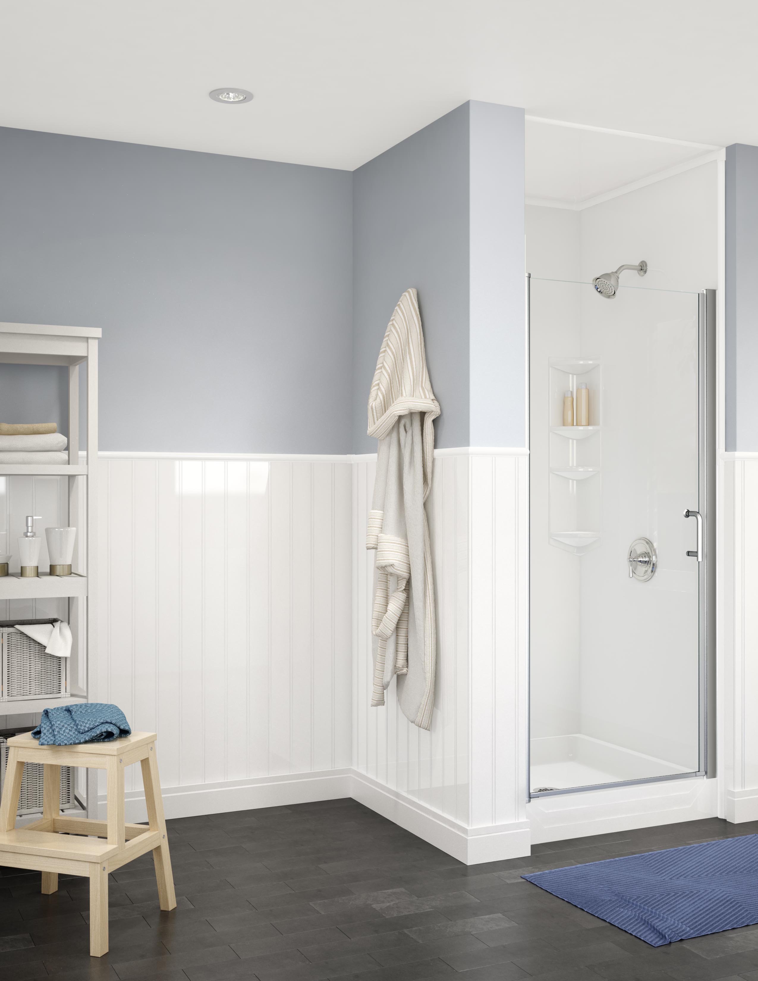 Contemporary bathroom featuring a compact glass-enclosed corner shower with built-in corner shelves and chrome fixtures. The room includes soft blue and white walls with vertical wainscoting, a robe hanging on the wall, open shelving with towels and toiletries, a small wooden stool, and a dark tiled floor with a blue mat. The space is clean, bright, and functional.