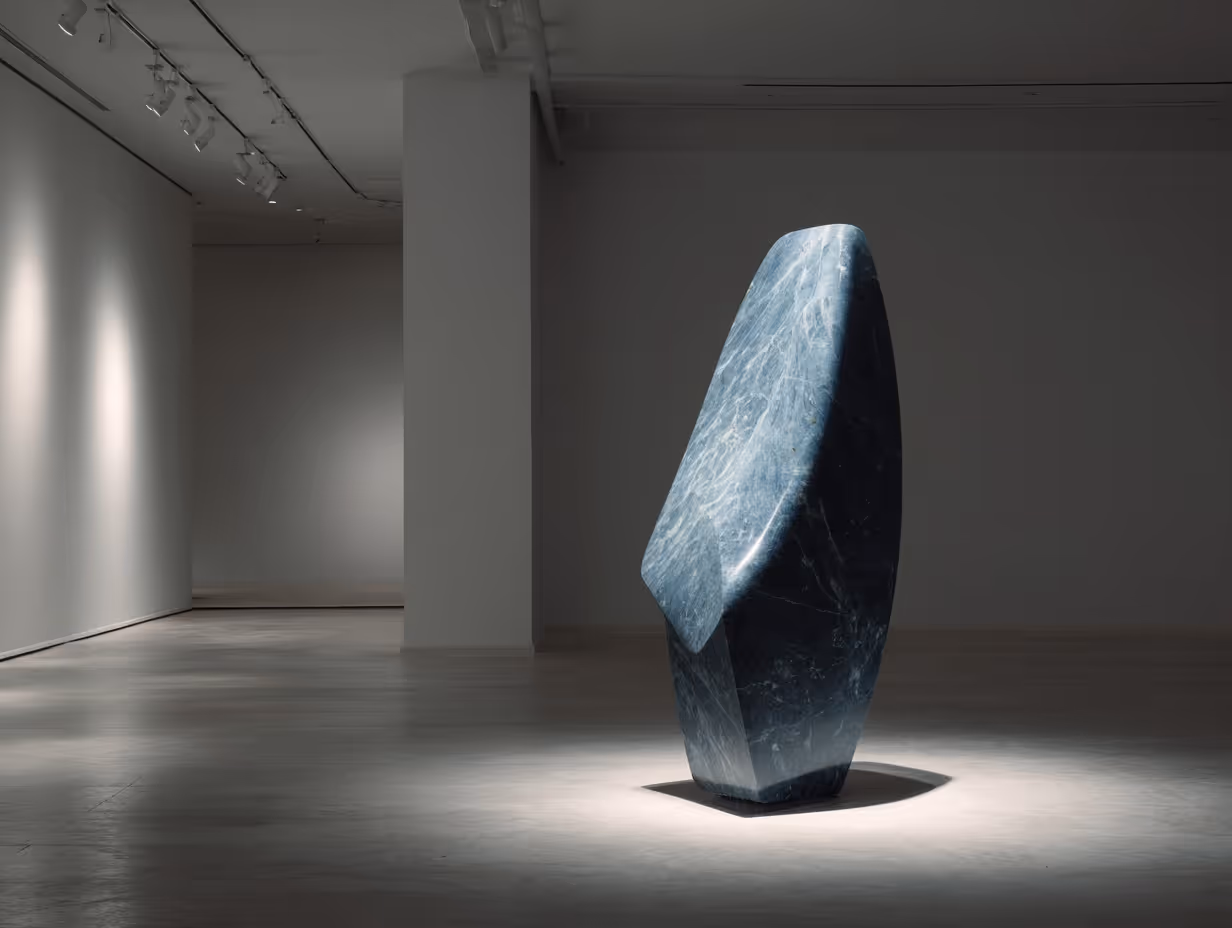 Polished abstract blue marble sculpture standing on a gallery floor illuminated by focused lights.