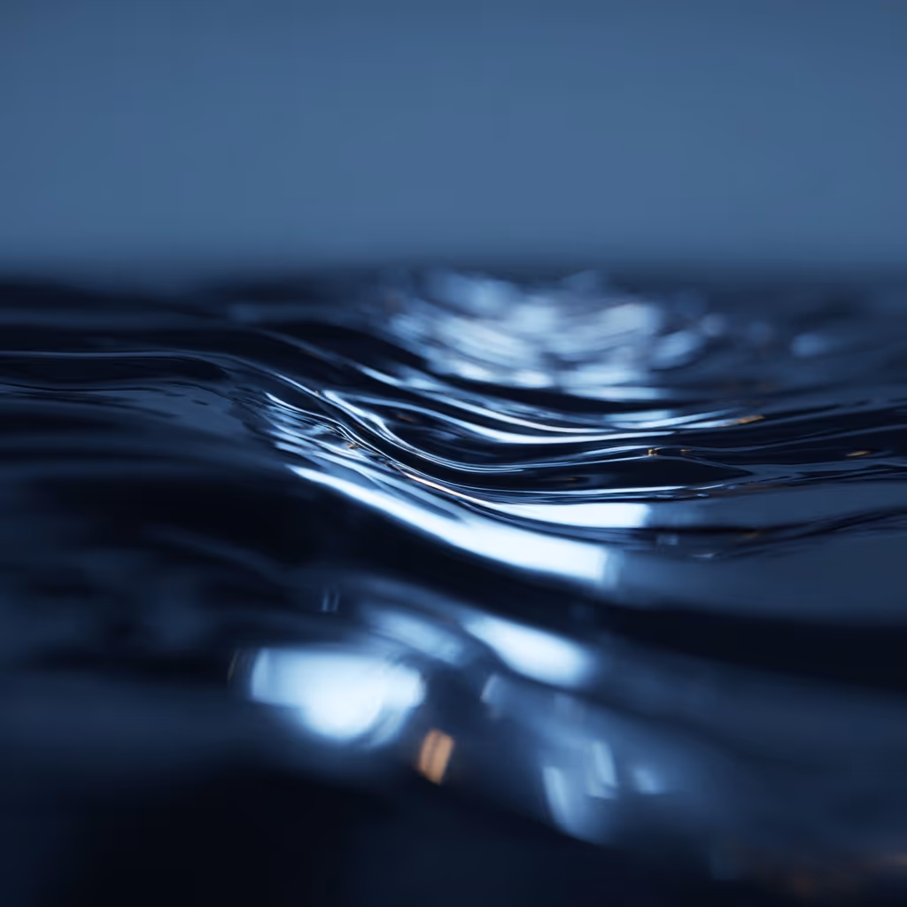 Close-up of calm, reflective water surface with gentle ripples under soft lighting.