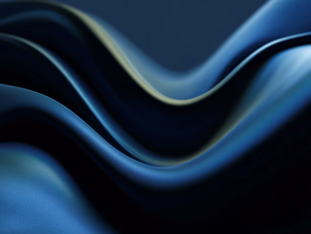 Smooth, dark blue fabric with soft waves and highlights creating a flowing texture.