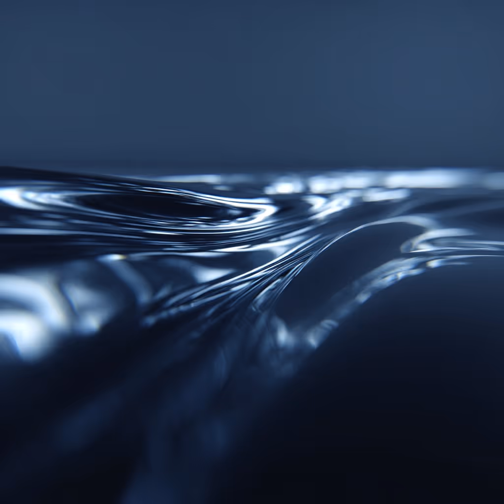 Close-up of smooth, reflective liquid surface with dark blue tones and light reflections.