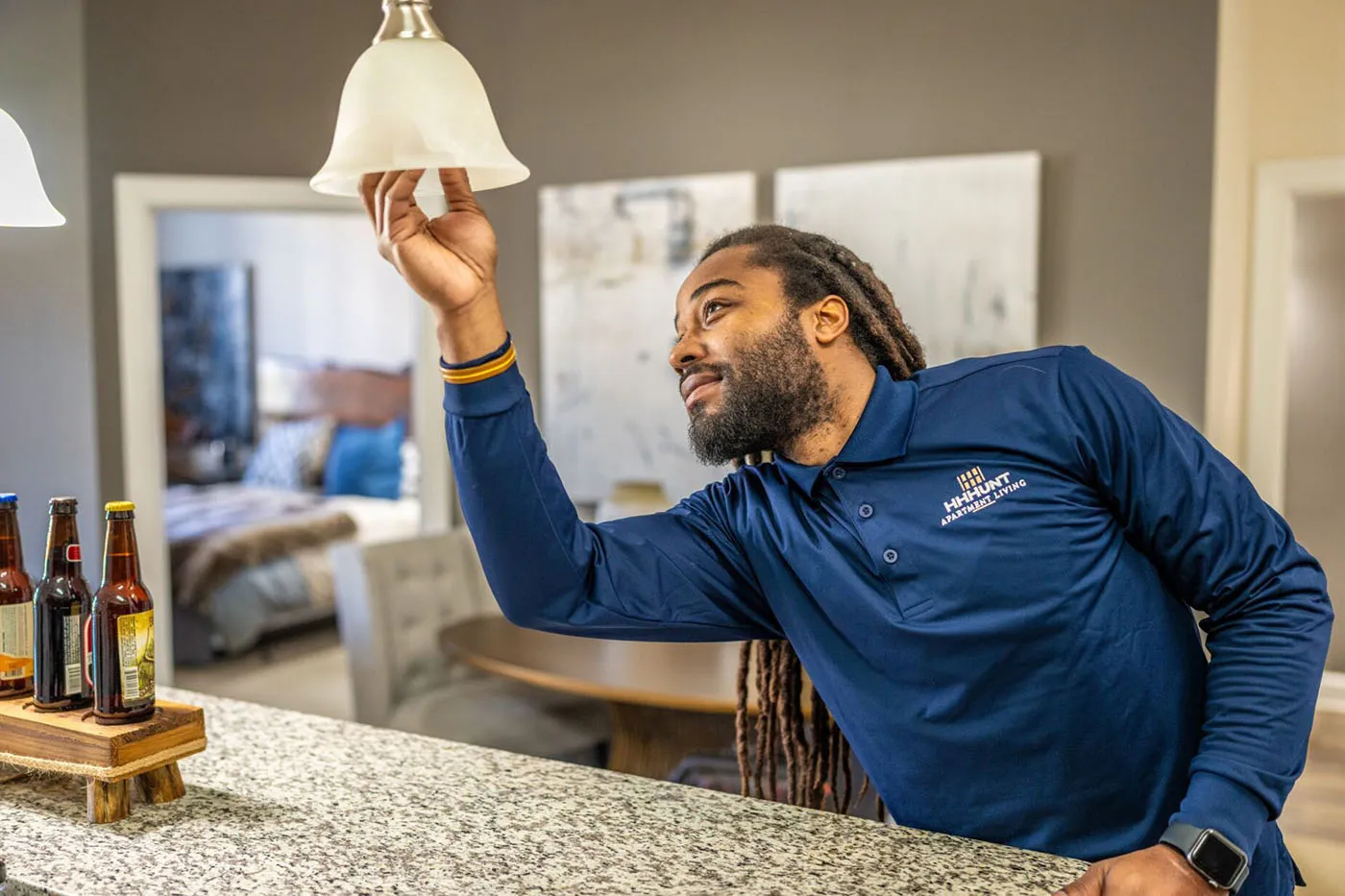 HHHunt Apartment Living employee changing the bulb in a fixture