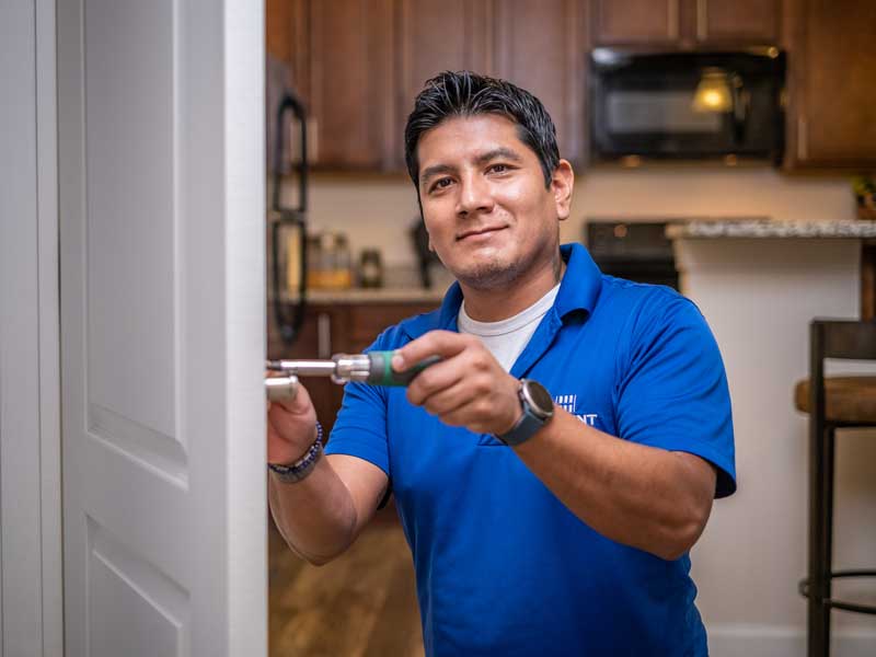 HHHunt Apartment Living maintenance worker fixing the door