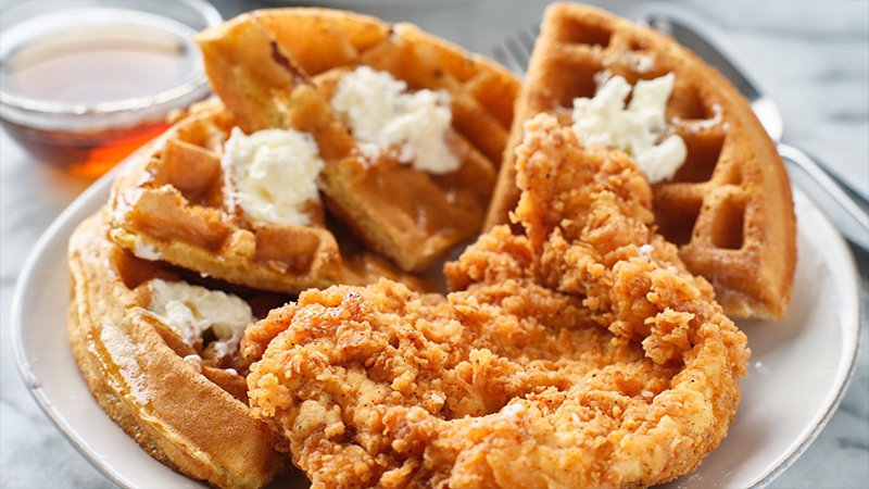 Chicken and waffles with syrup.