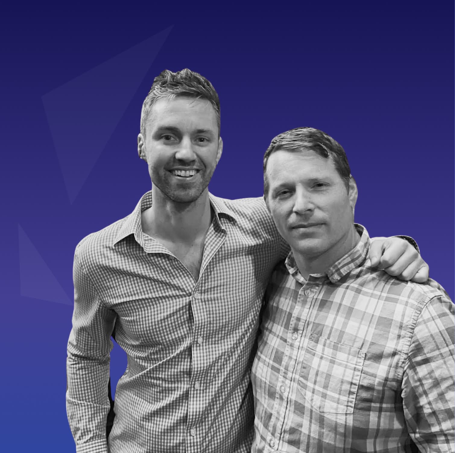 Two smiling men in plaid shirts standing together on blue background