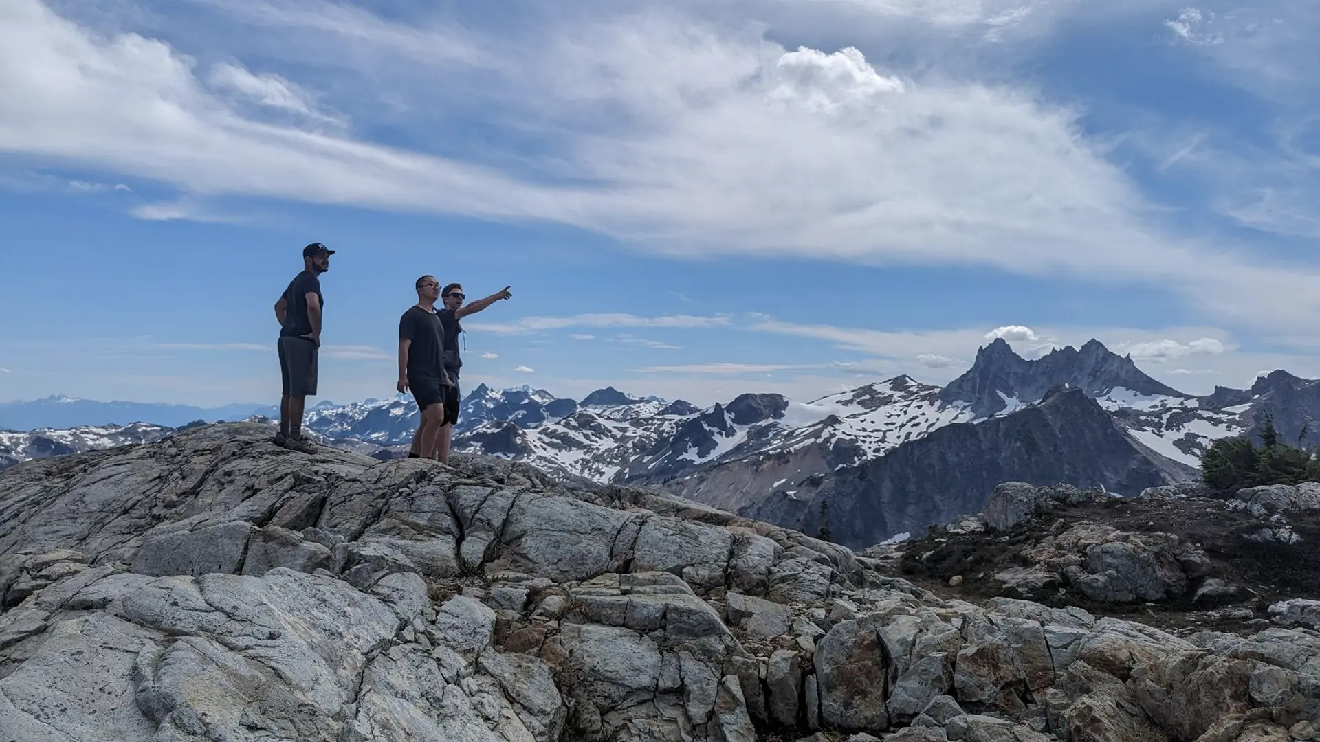 Two people on top of a mountain, hiking.