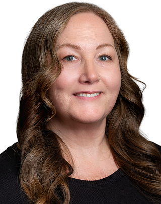Smiling woman with wavy hair and glasses in professional headshot