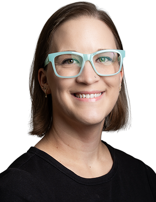 Smiling woman with glasses wearing black shirt and long hair