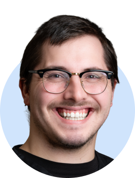 Smiling person wearing glasses in black shirt against light blue background