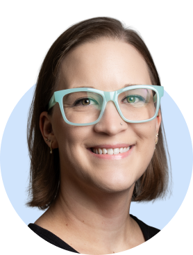 Smiling person with glasses wearing black shirt against light blue background