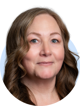 Smiling woman with wavy reddish-brown hair and black-rimmed glasses