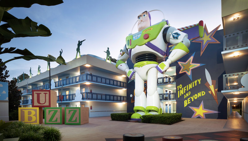 Giant Buzz Lightyear statue at Disney’s All-Star Movies Resort with Toy Story-themed buildings at sunset