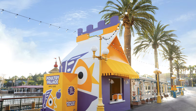 Colorful Poultry Palace food stand at Disney California Adventure with palm trees and Pixar Pier theming