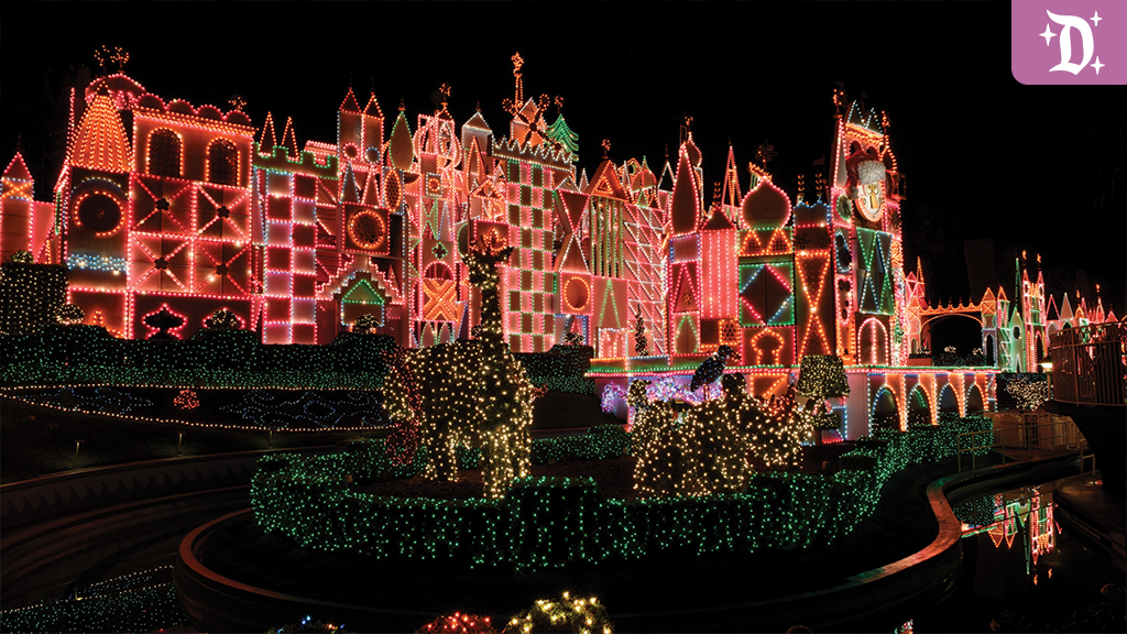 "it's a small world" Holiday facade lit up at night with colorful string lights, topiary reindeer, and festive decor at Disneyland