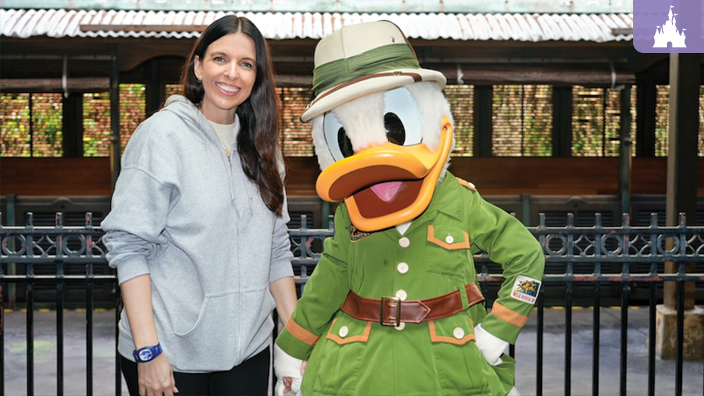 Guest smiling beside Donald Duck in safari outfit at Disney's Animal Kingdom Theme Park