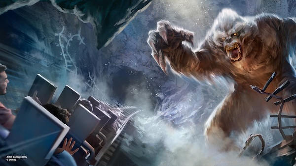 A giant furry monster lunging at passengers on a roller coaster train racing through a rocky tunnel