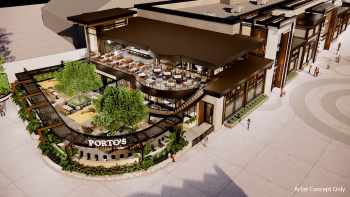 Two-story restaurant with Porto's sign, curved staircase to upper dining terrace, ground-level patio seating and landscaping around entrance