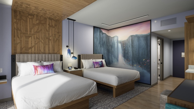 Two beds with gray headboards under wood accent wall, wall-sized waterfall mural, bedside table with hanging lamps, wood floor