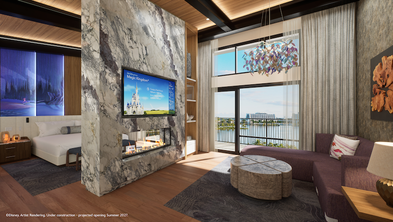 Modern hotel suite with marble fireplace wall and mounted TV, plush sofa and coffee table, floor-to-ceiling windows opening onto a lakeside balcony.