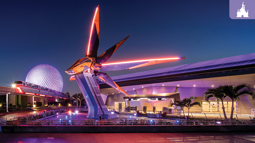Geodesic sphere lit in purple at dusk, monorail passing an illuminated pavilion with a red neon-lit futuristic sculpture over a reflecting pool.