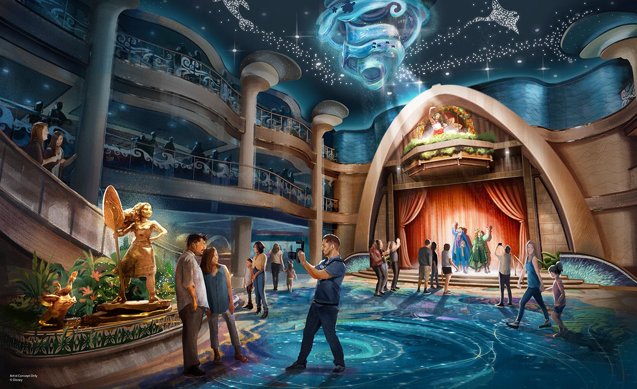 Multi-level atrium lobby with a small stage performance, decorative floor and ceiling lights, guests taking photos and viewing golden statues.