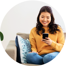 Asian woman in a yellow sweater looking at her phone