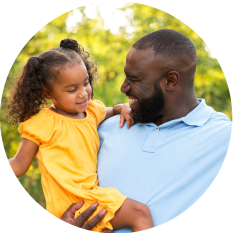 A father holding his daughter in a yellow dress