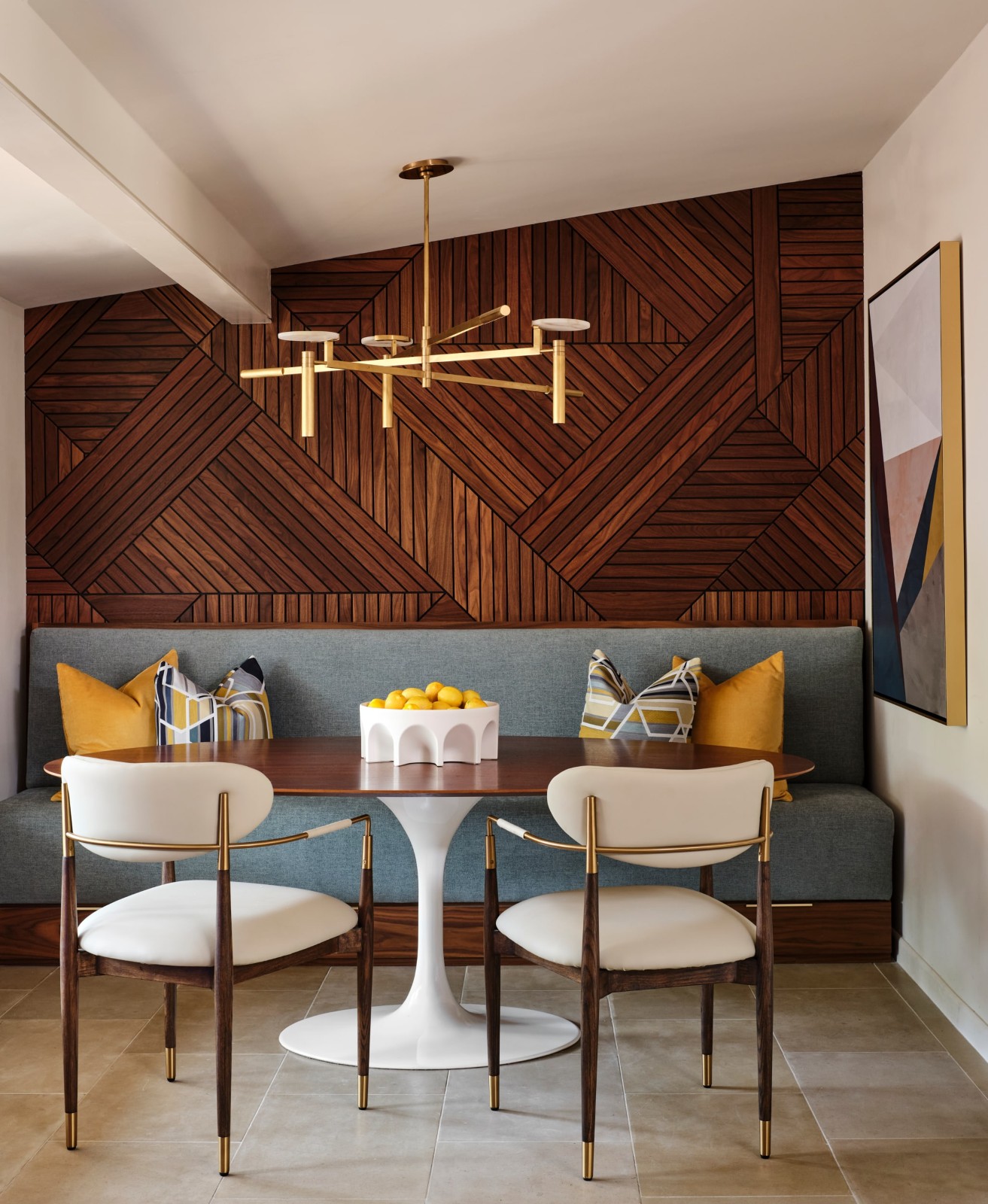 Modern dining nook with wood wall, gray bench, and gold accent lighting
