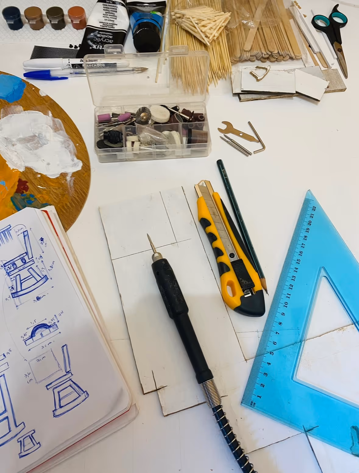 Cutting mat with sketches, ruler and tools arranged on bright workspace