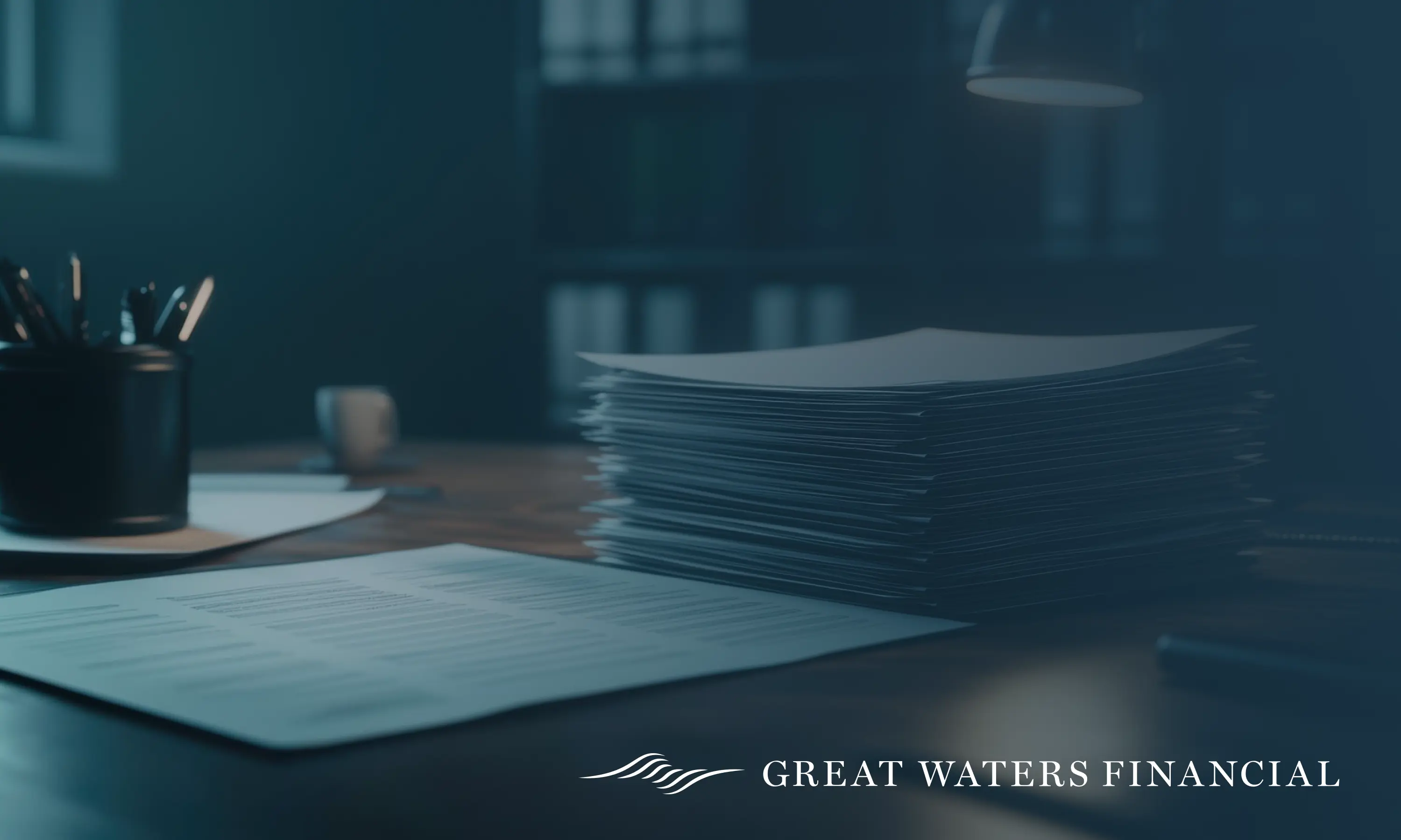Stack of documents and a single document on a wooden desk under soft lighting with Great Waters Financial logo.