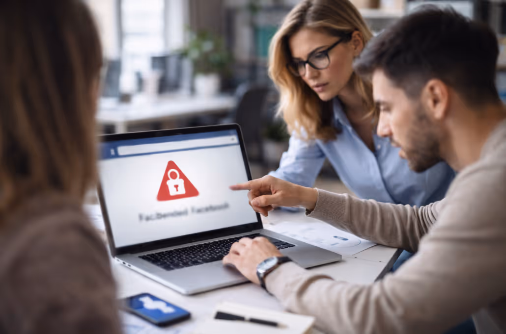 Three office workers collaborating to resolve a suspended Facebook account