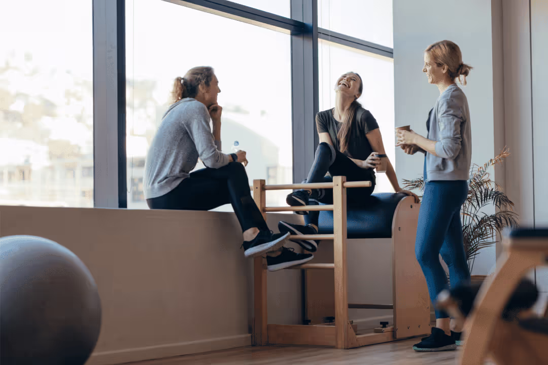 women chatting and laughing in gym after a workout