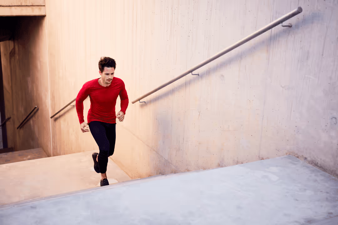 young man running up stairs outdoor exercise red shirt
