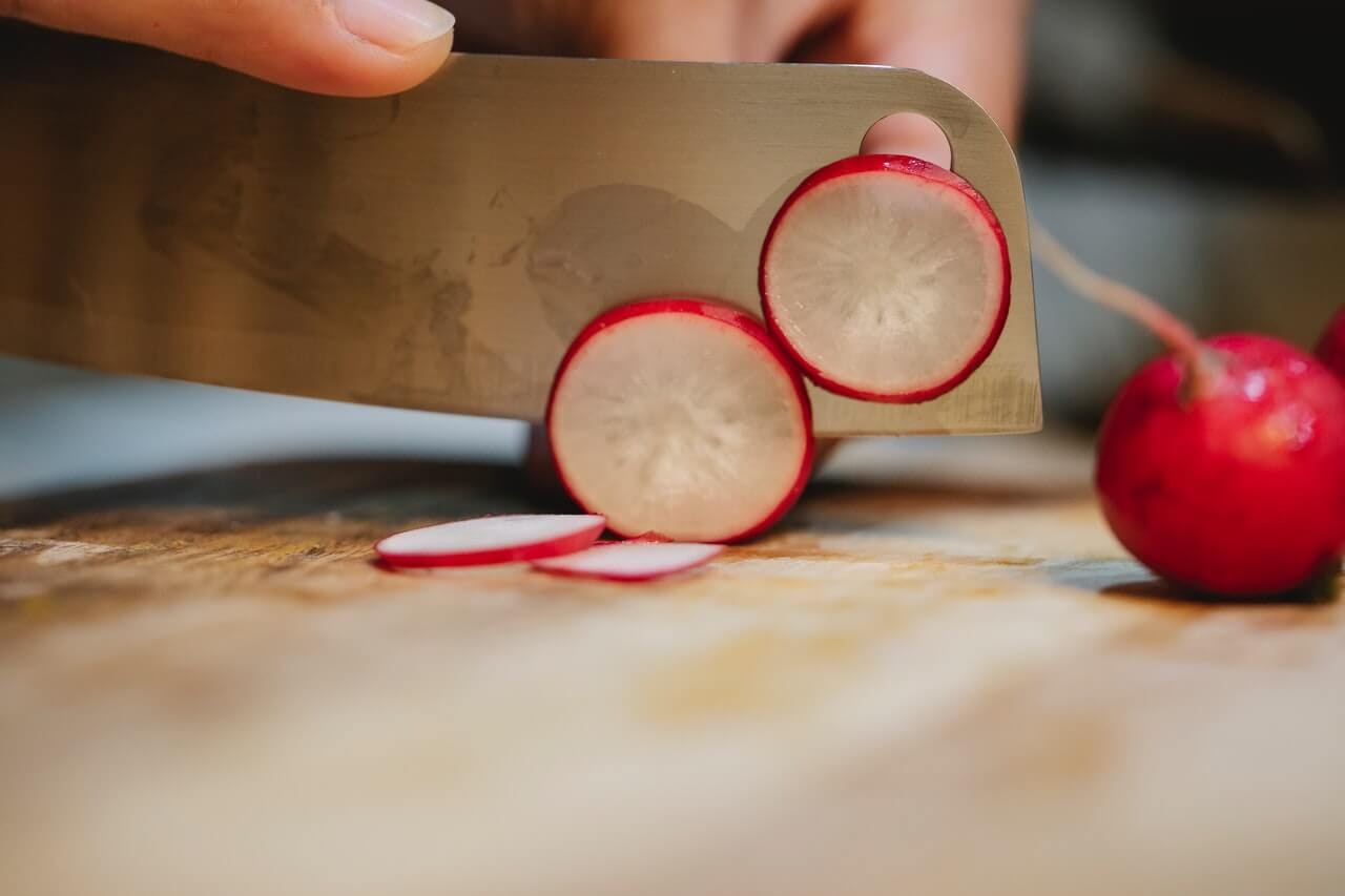 cutting a radish big knife cutting board kitchen