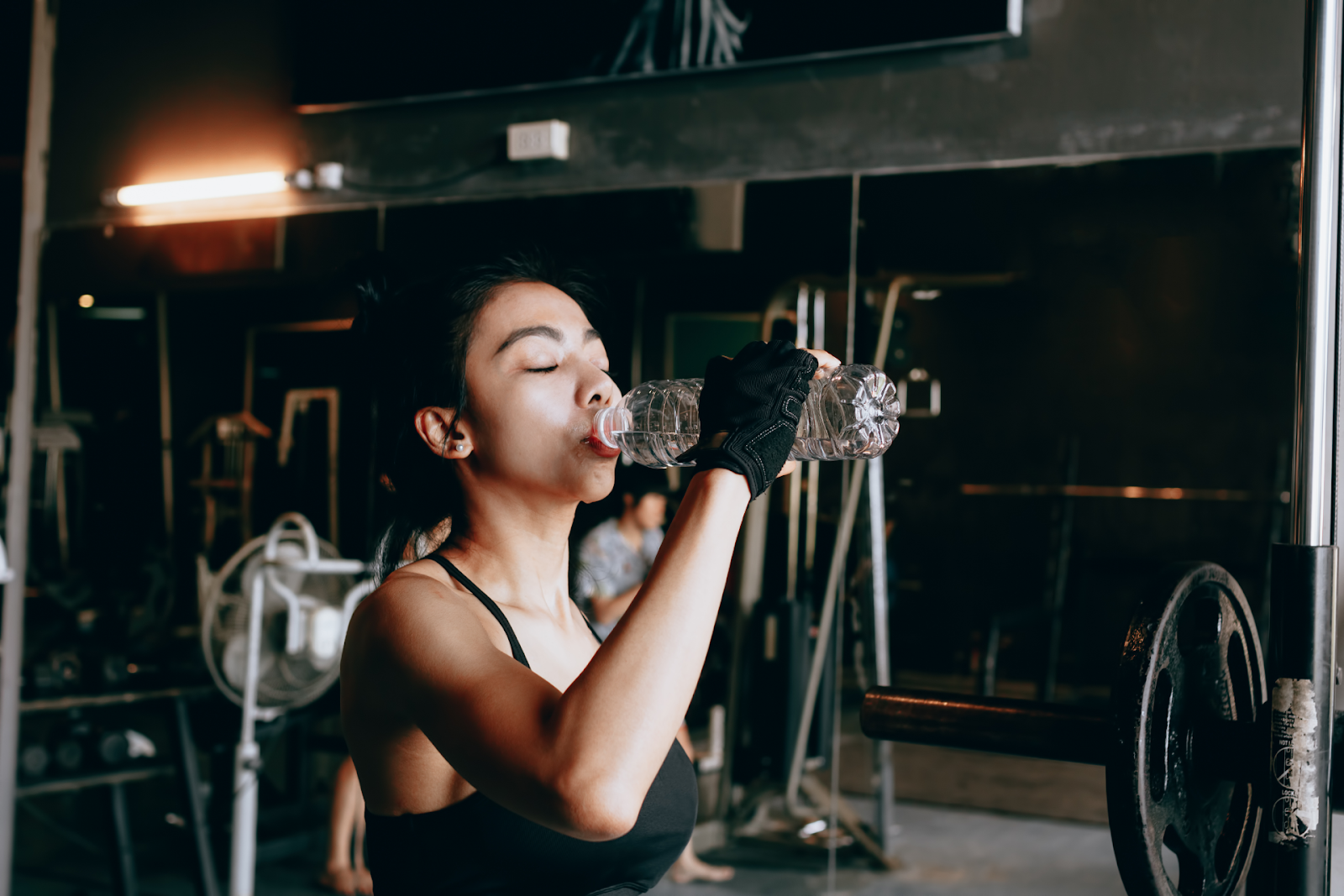 woman drinking water in gym