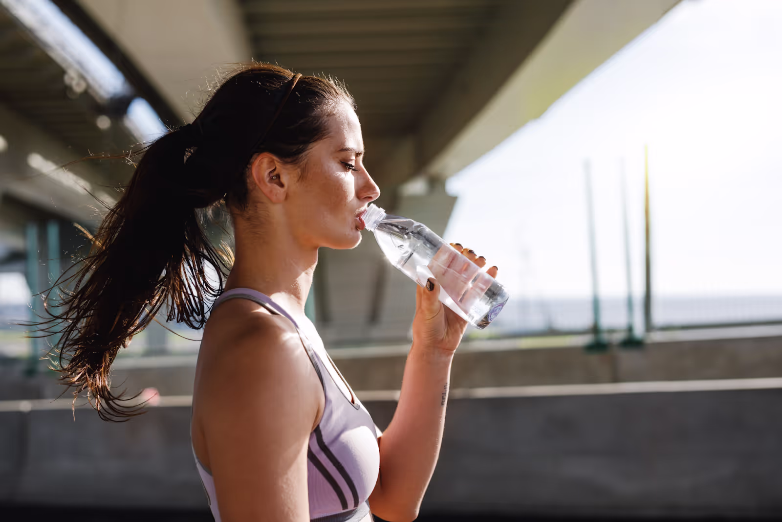 woman drinking out of water bottle