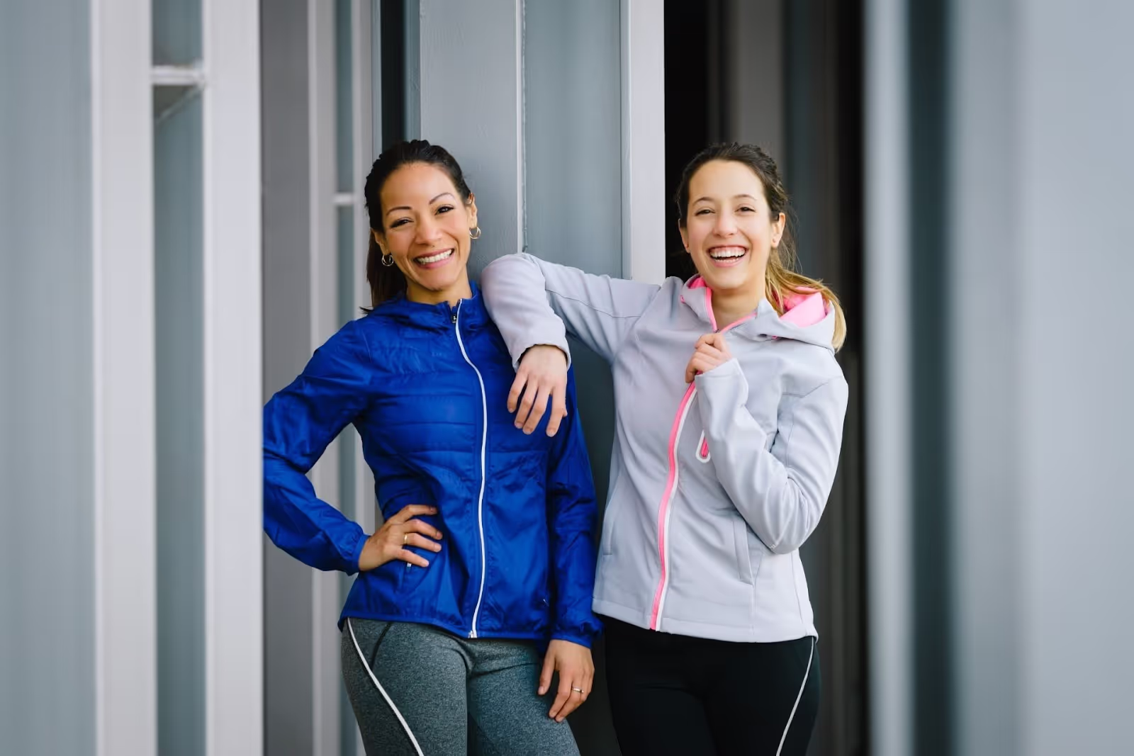 two woman standing outside in athletic outfits