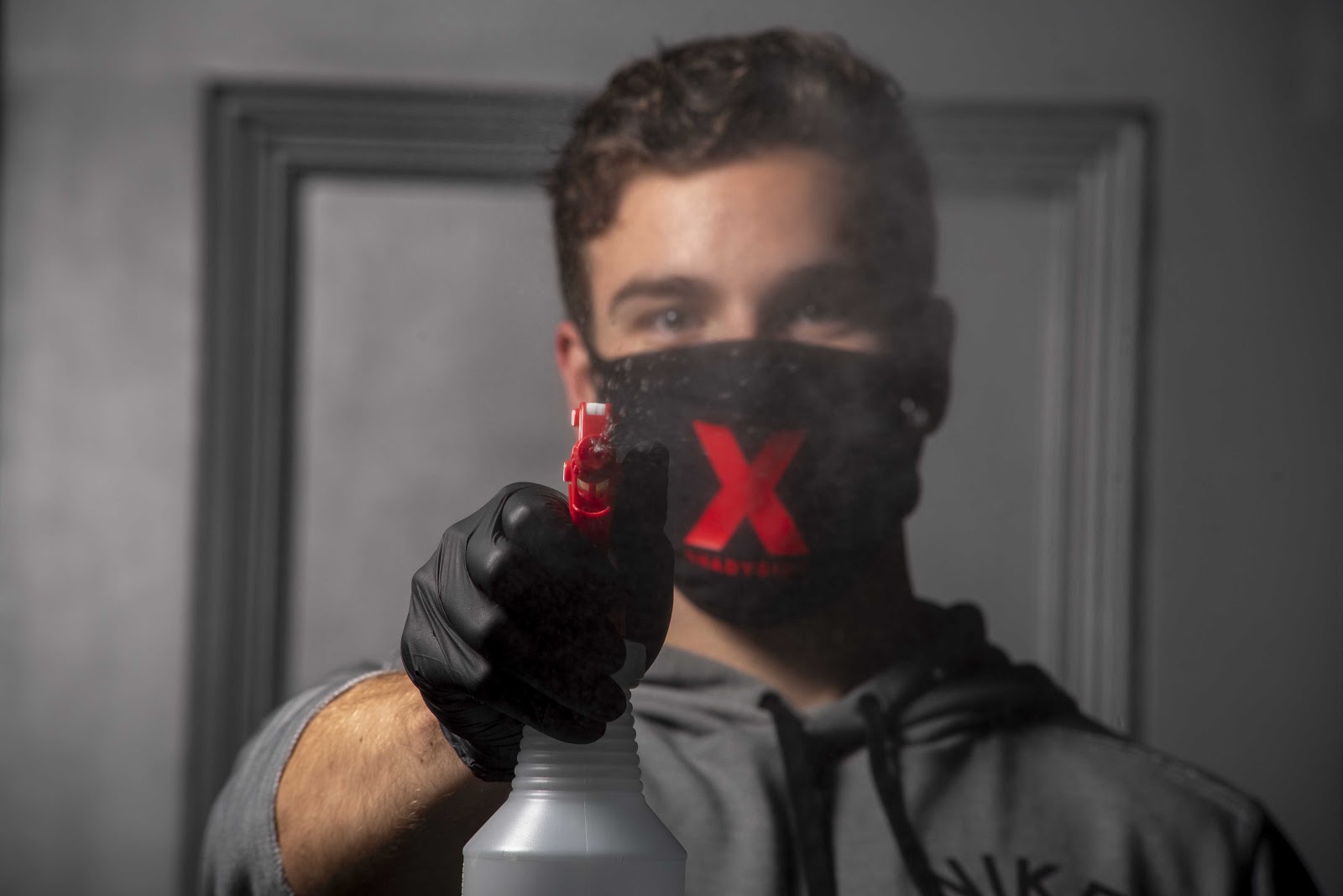 man with mask cleaning mirror