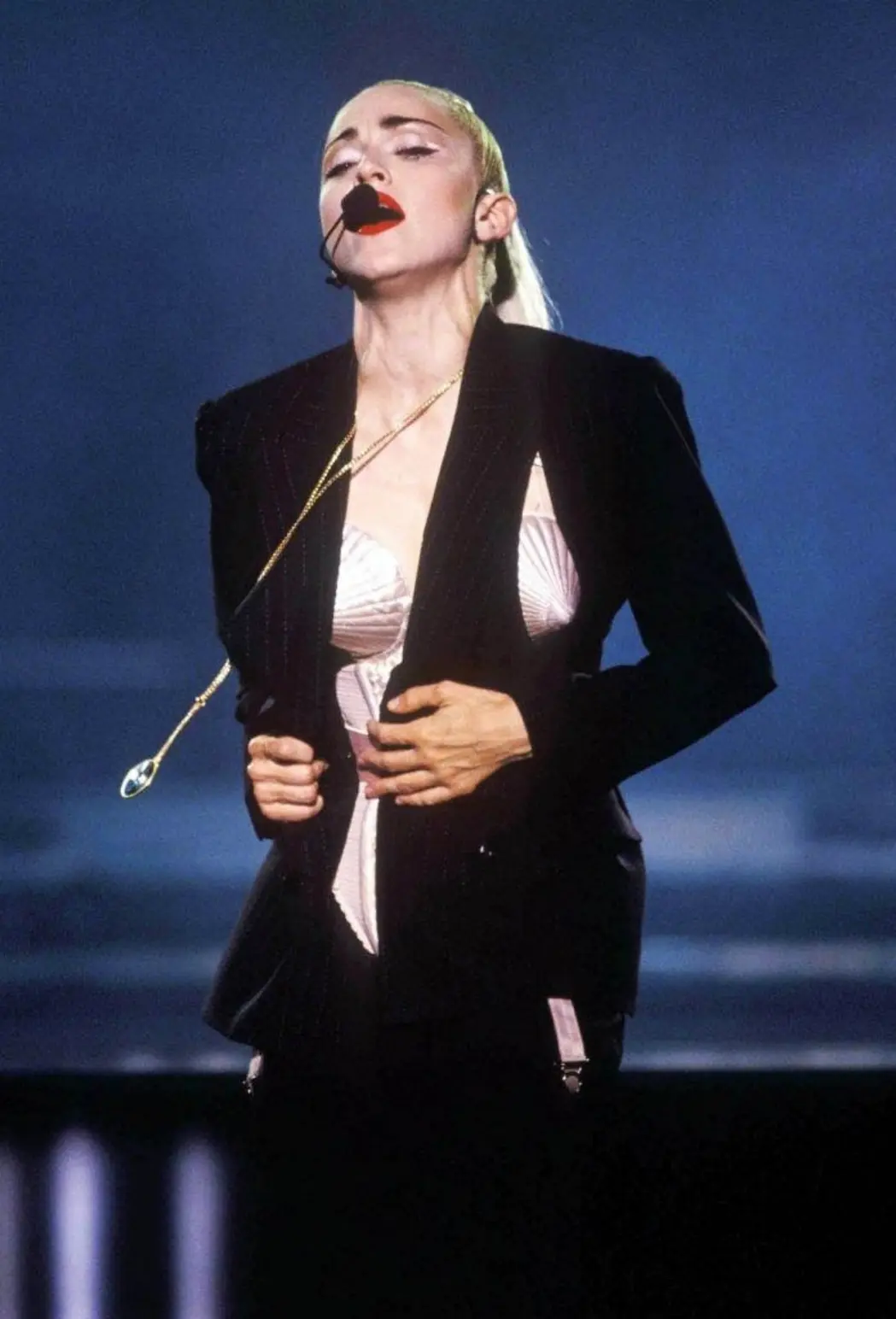 Madonna opening the Blond Ambition Tour in a pinstripe suit with breast cut-outs revealing her cone bra, 1990