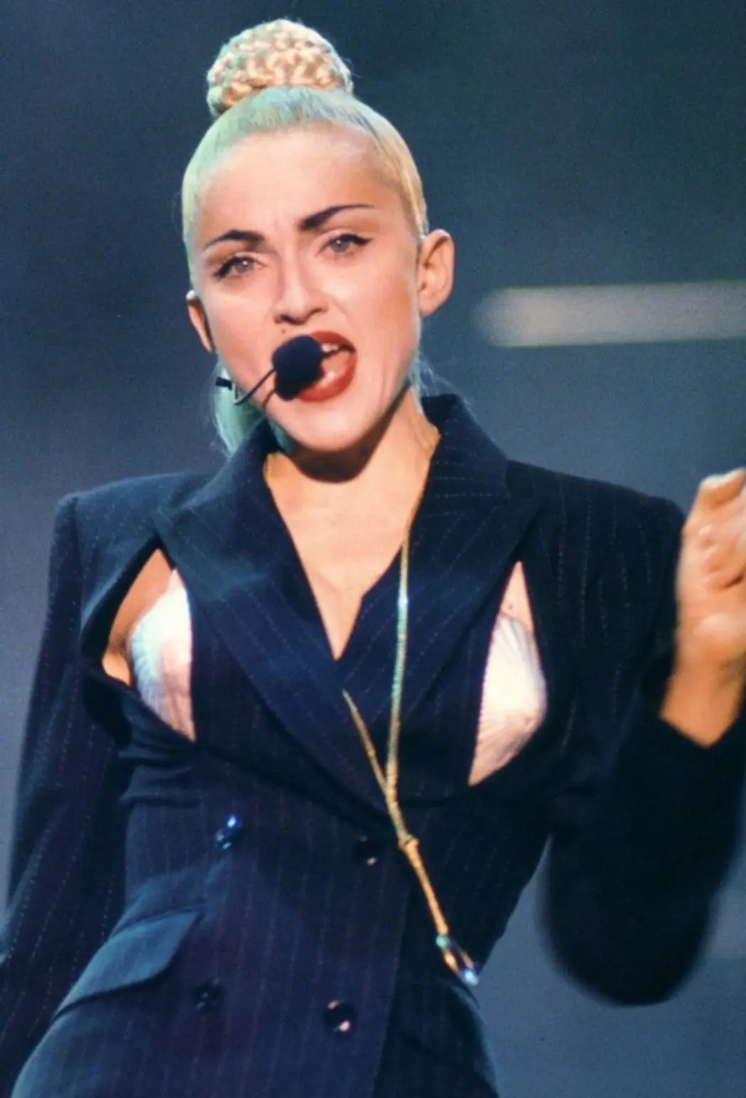 Madonna opening the Blond Ambition Tour in a pinstripe suit with breast cut-outs revealing her cone bra, 1990